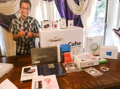 A-smiling-Ahmed-Mohamed-stands-with-the-Surface-Pro-3-and-other-goodies-he-received-from-Microsoft